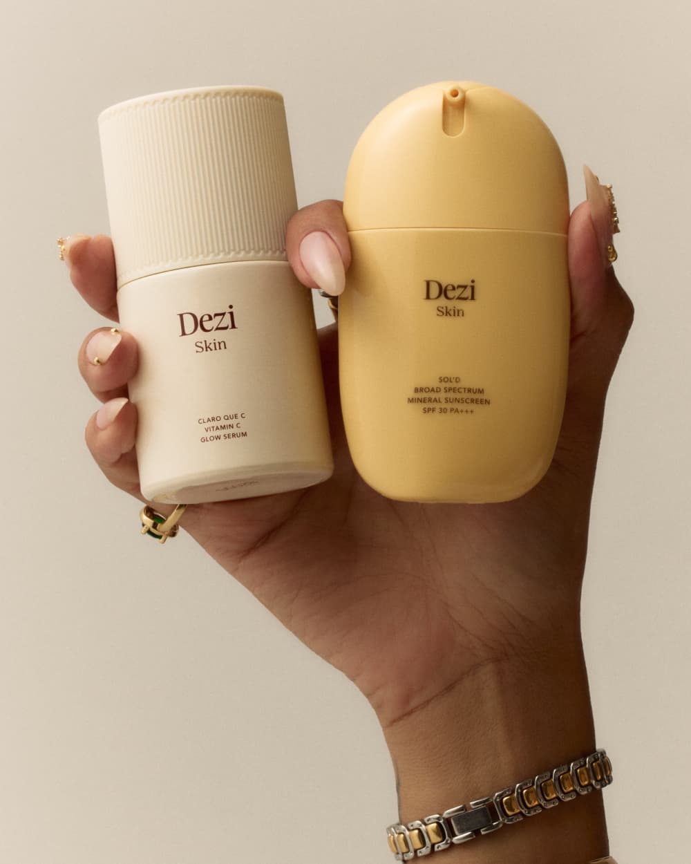 hand holding dezi skin claro que c vitamin c glow serum and sol'd broad spectrum mineral sunscreen spf 30