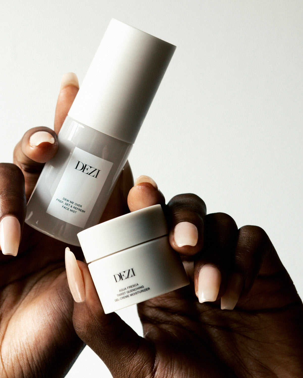 hands holding the two travel size skincare products. the mist and the moisturizer. 